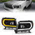 ANZO 05-11 Toyota Tacoma Projector Headlights w/Light Bar Switchback Black Housing - Striker Modified